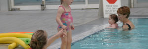 A mother helps her daughter learn to swim at a mommy and me class in Plano, Texas