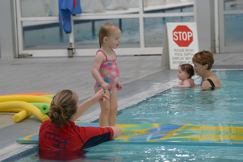 A mother helps her daughter learn to swim at a mommy and me class in Plano, Texas