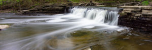 A waterfall meets the river at a nature-filled experience in Westmont, Illinois