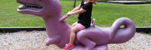 A young girl plays on a purple dinosaur at a park in Buckhead, Georgia