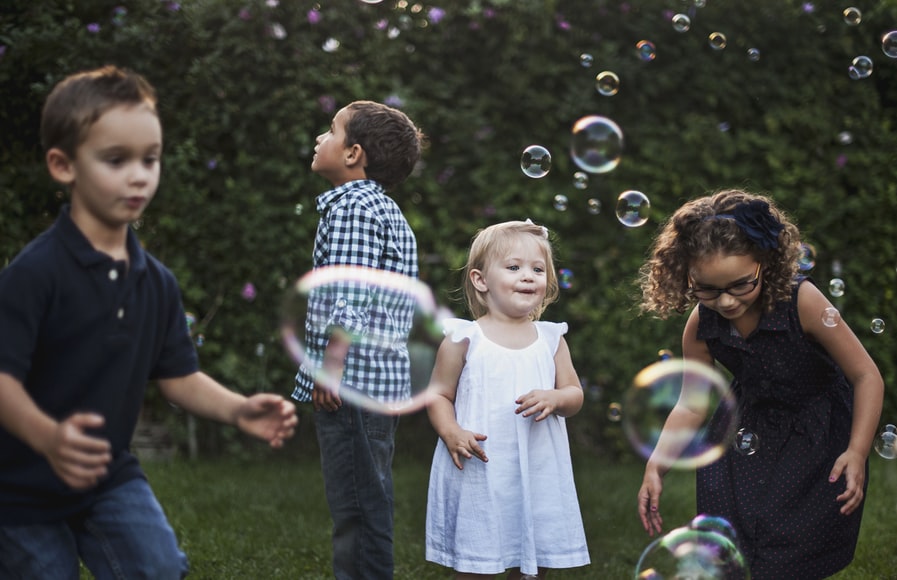 Four kids having fun blowing bubbles