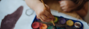 Little girl mixing paint pallet for an art project.