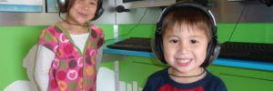 Two children using audio headsets to take a language class.