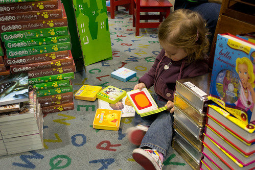 Small child reading books on the floor.
