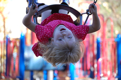 Little girl swinging happily.
