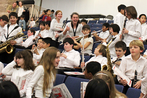 Image of an orchestra hall filled with school aged children.