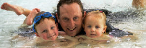 Father and two children enjoying a day at a waterpark.