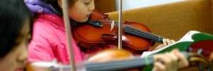 Child playing the violin in a Lone Tree, CO music class.