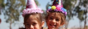 Two small girls wearing birthday hats at a Las Vegas party.