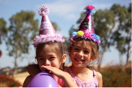 Two small girls wearing birthday hats at a Las Vegas party.