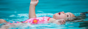 Baby floating in safety pool.