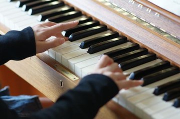 A child's hands playing the keys on a piano in a Coppell, TX music class.