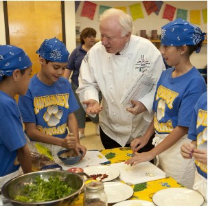 Children work in a kids cooking class alongside their chef.
