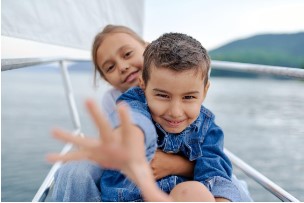 Two children playing on a sailboat.