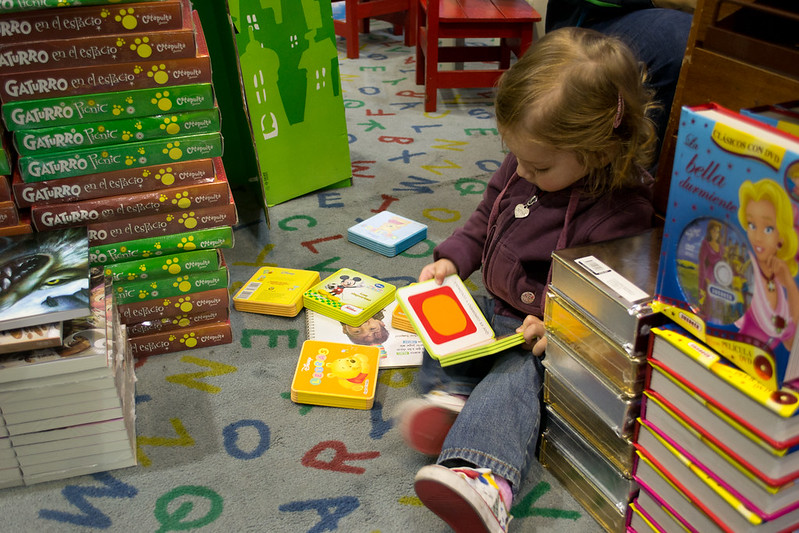 Child reading a book on the floor of a local bookstore in Allen, Texas