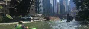 Man riding a kayak in Chicago, IL waterway.