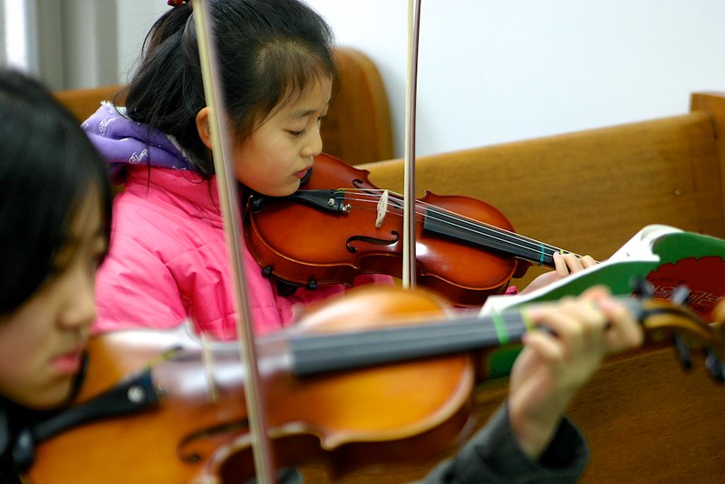 Two small children learning how to play the violin in Allen, TX