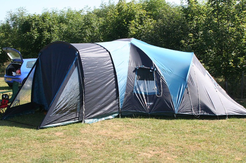 A tent set up for camping in a field near woods in Alpharetta, GA