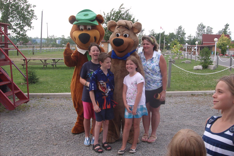 A happy family posing for a photo with Yogi Bear at Jellystone Park in Ellisville, MO