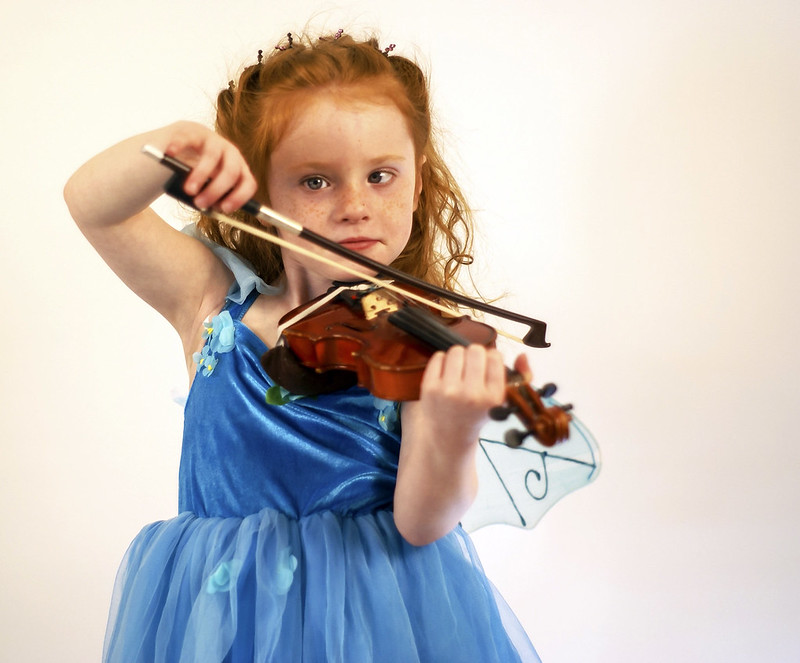 A young, redheaded girl in a fairy dress playing violin in Peoria, AZ