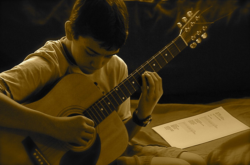 A young boy playing guitar at a music lesson in Gilbert, AZ