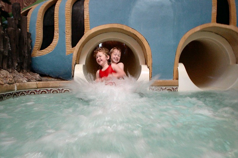 Two kids emerging from a water slide into a pool at Great Wolf Lodge in West Chester, OH