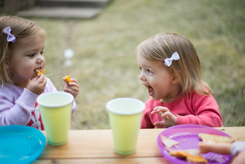 Two children at a picnic table enjoying snacks in Carmel, IN