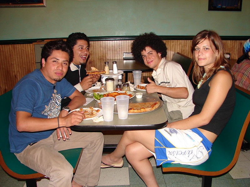 A group of young people enjoying pizza and buffalo wings in Allen, TX