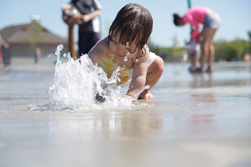 A small child playing in a splash pool in Marietta, GA