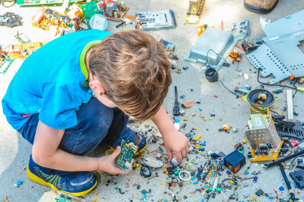 A young child puts tiny pieces together for an electric circuit board.