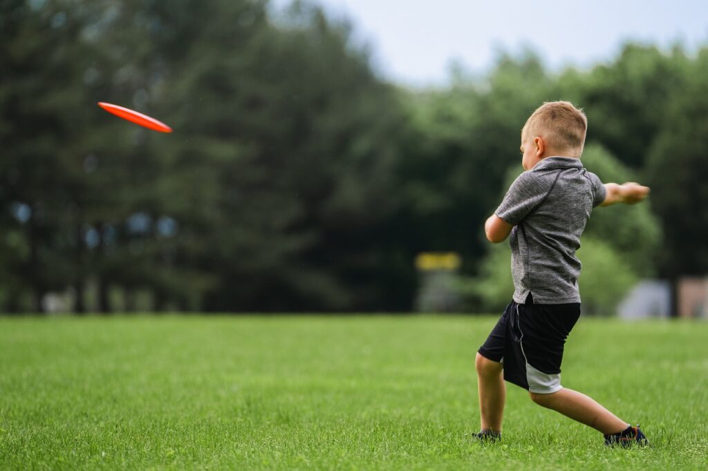 A child throws a red frisbee in Willis Park near Alpharetta, GA