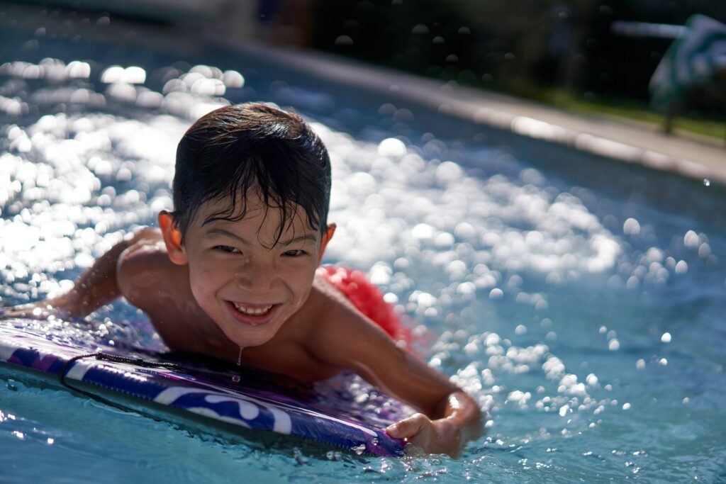 Child in a swimming pool with a boogie board in Chanhassen, MN