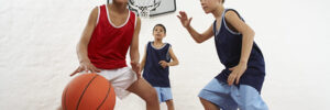 3 kids playing basketball in a gym