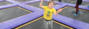 young boy jumping at an indoor trampoline park