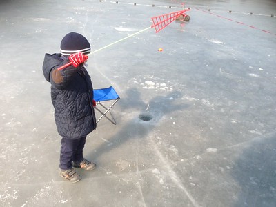 A child participates in ice fishing at an annual event in Chanhassen, MN