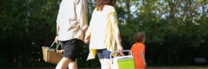 Man and Woman Walking at the Park with Child for a picnic