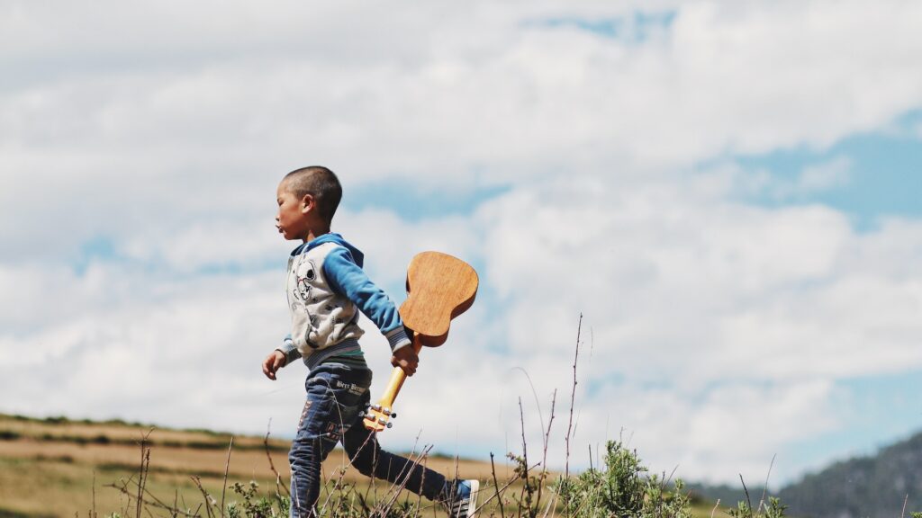Child with a ukelele, walking in a field in Texas
