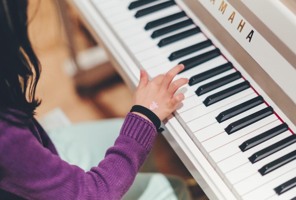 A child playing a Yamaha piano at a music lesson in Texas