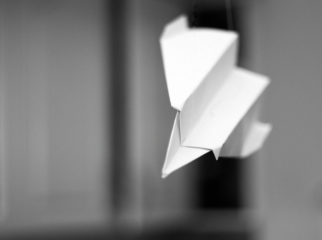 A paper airplane flying across a room