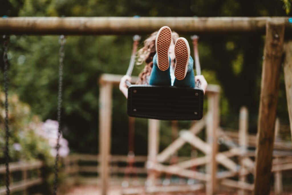 A child on a swing in a playground in Colleyville, TX