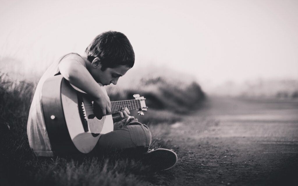A child playing a guitar outside in Ohio