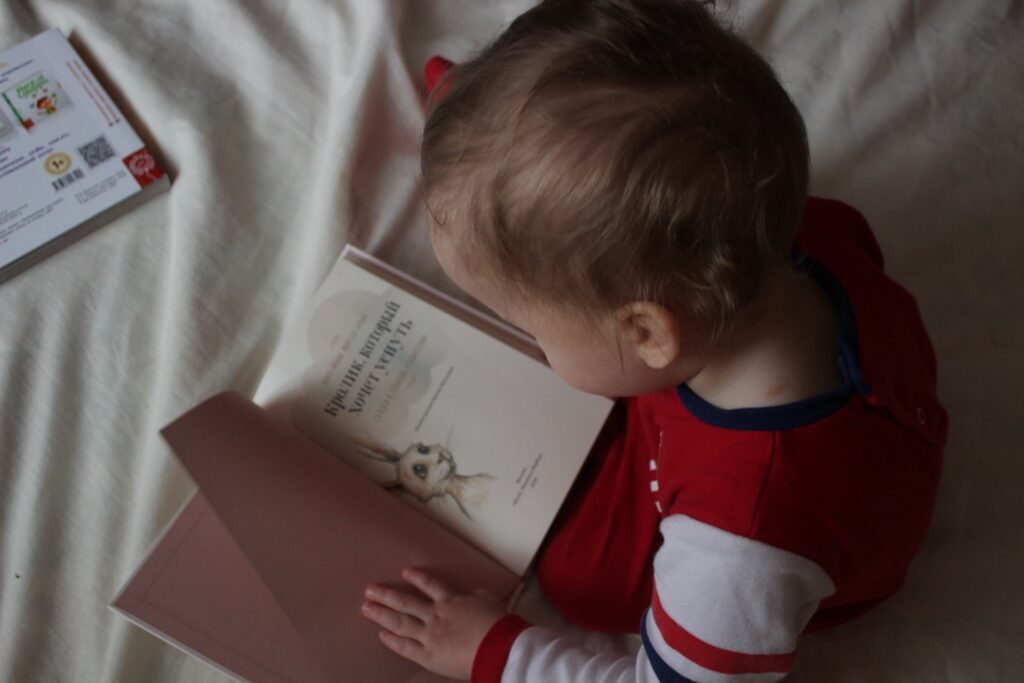 A child in bed reading a book.