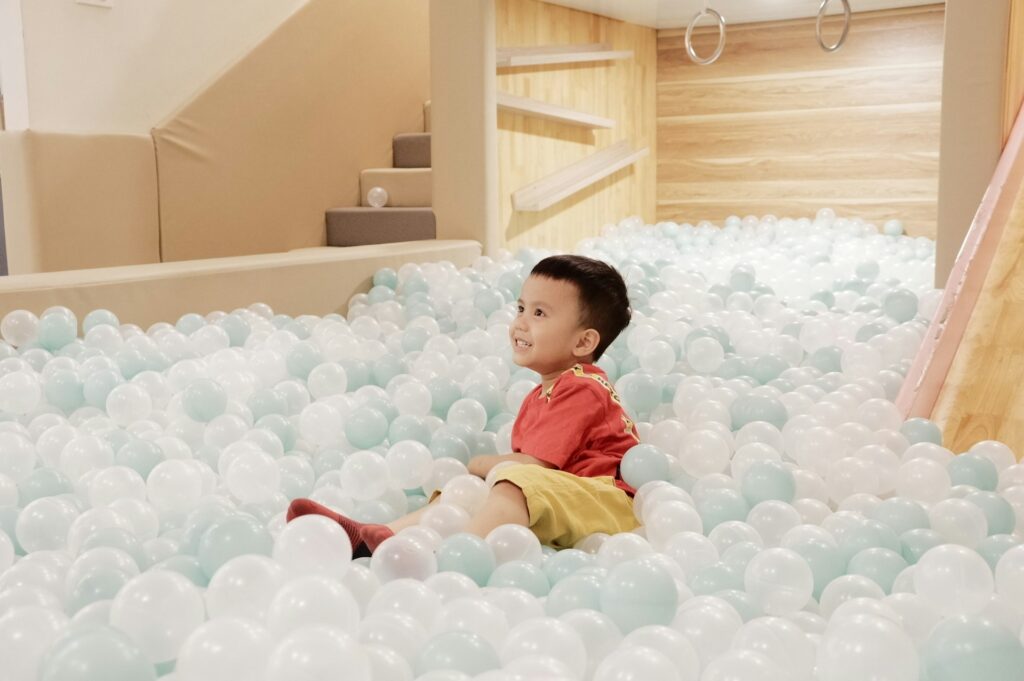 A child sitting in a ball pit at an indoor playground in Colleyville, TX