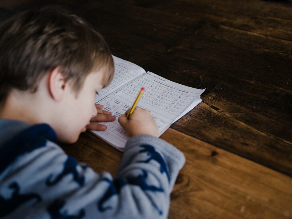 A child writing in a school notebook in Allen, TX