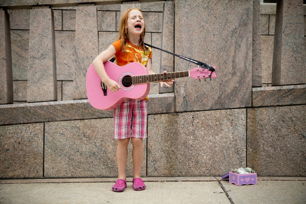 A young girl singing and playing a pink guitar in West Chester, OH