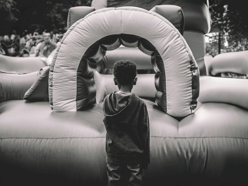 A child standing in front of a bouncy castle in Carmel, IN