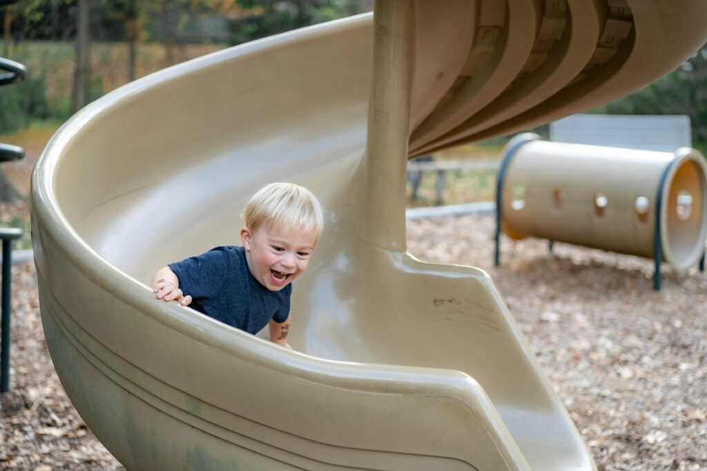 A child going down a slide at a playground in McKinney, TX
