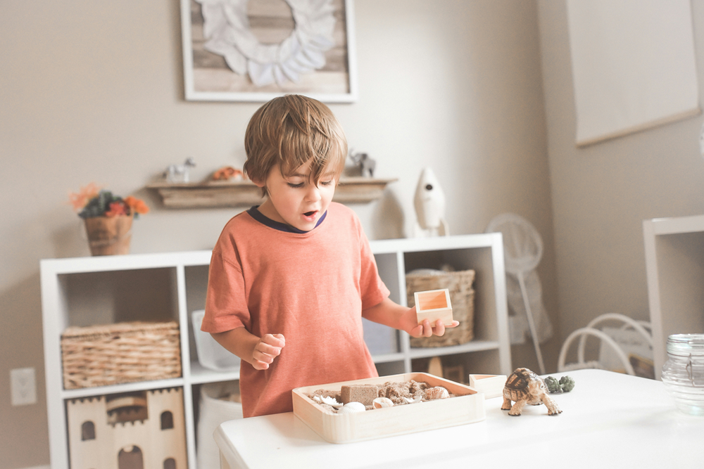 Young boy playing with shapes and blocks in classroom