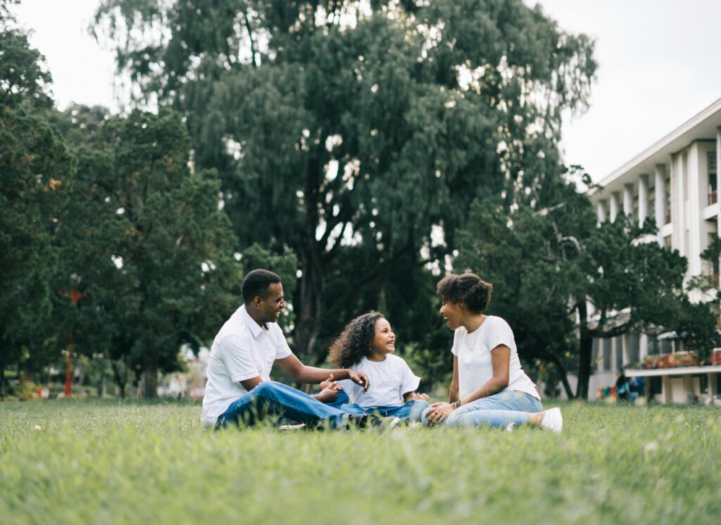 Family sitting on grass having a picnic