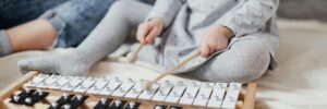 Child playing a xylophone on the floor